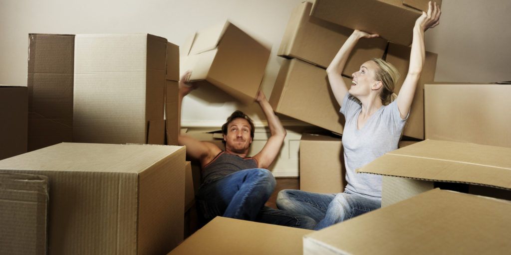 Adult couple emerging from moving crates